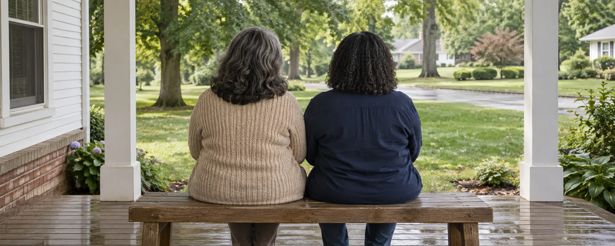 Two adults sitting together on a porch bench, seen from behind